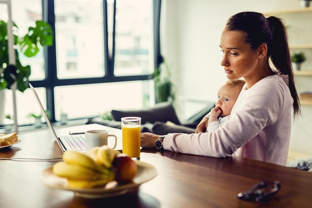 Displeased mother with a baby thinking of something while experiencing postnatal depression