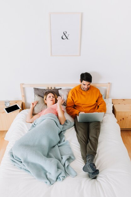 Displeased woman arguing with man with laptop