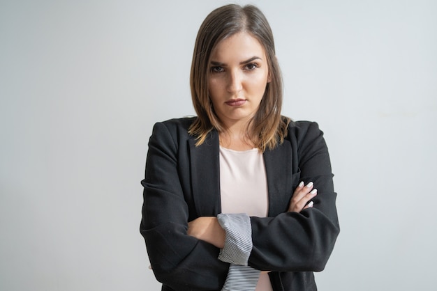 Foto gratuita giovane donna di affari caucasica dispiaciuta con le braccia attraversate