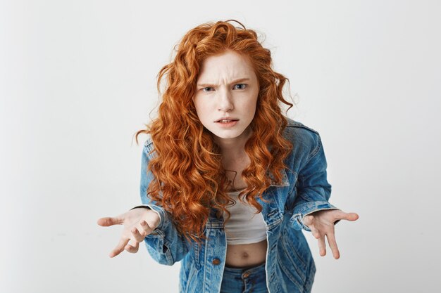 Displeased young foxy girl stretching to camera looking brutally gesturing .