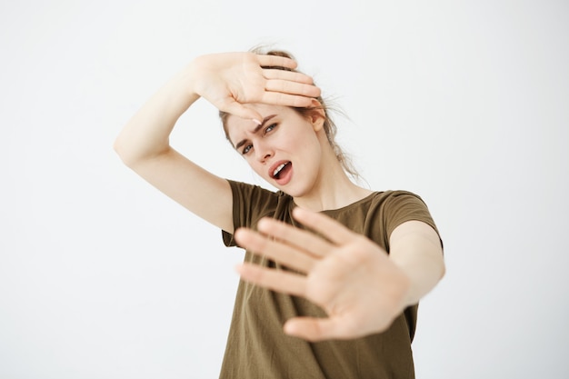 Displeased young woman hiding behind hands