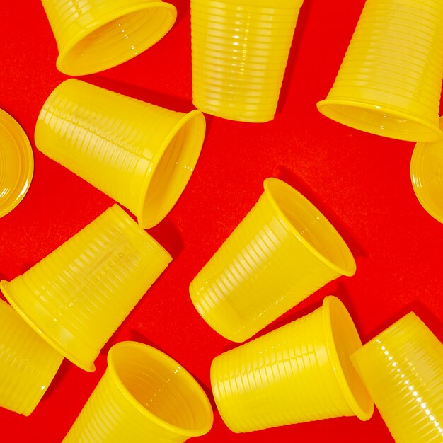 Disposable plastic cups on red background