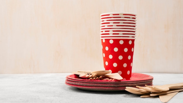 Free photo disposable tableware pile of red with white dots cups
