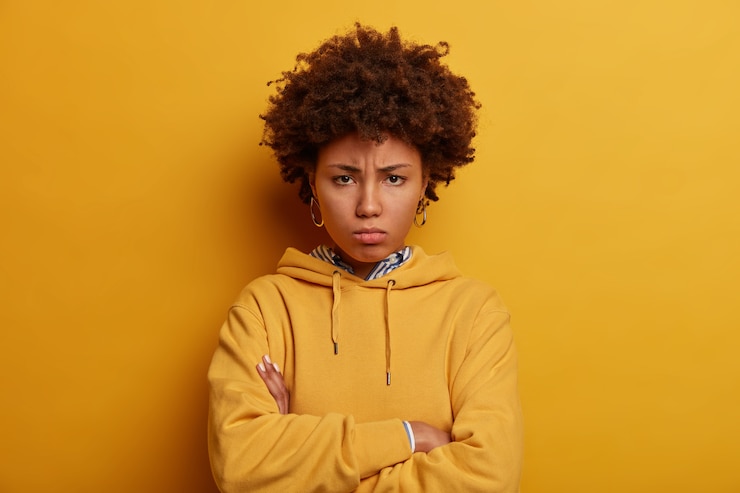 Free Photo dissatisfied afro american woman looks from under forehead