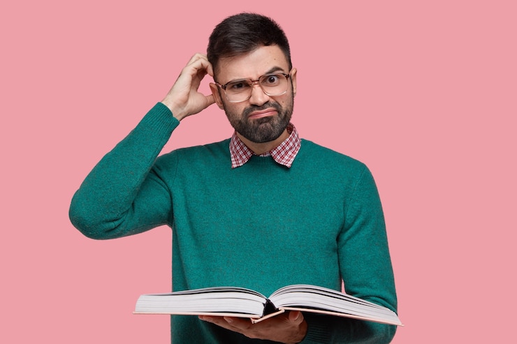 Free Photo dissatisfied caucasian man with thick bristle, scratches head in bewilderment, wears spectacles and green sweater