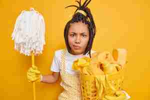 Free photo dissatisfied young african american woman poses with mop