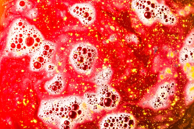 Free photo dissolve of red bath bomb with bubble background