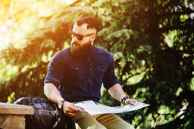 Distracted man with a map at sunset