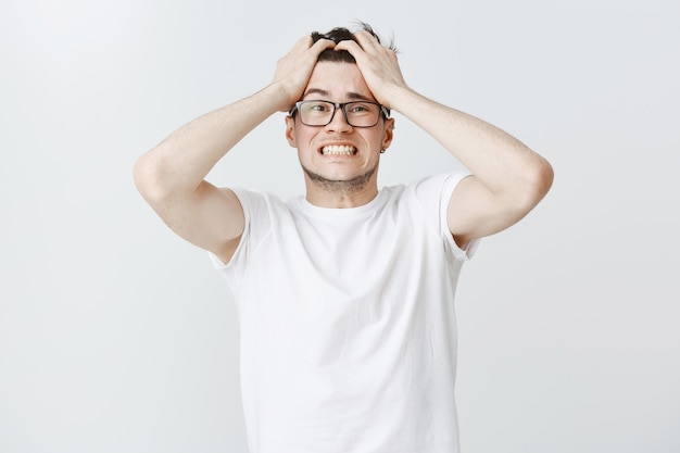 Distressed guy in panic grab head and looking anxious