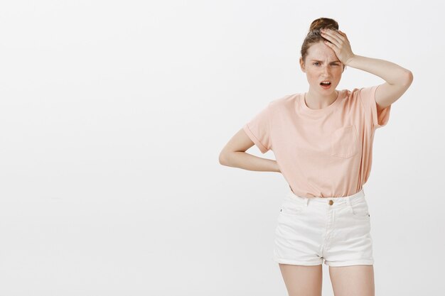 Distressed and worried teenage girl posing against the white wall