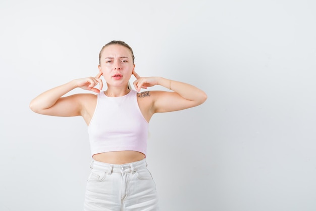 Disturbed girl is closing her ears on white background