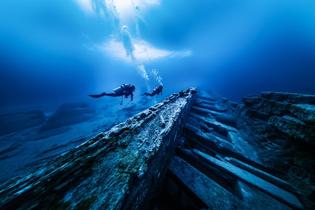 Foto gratuita immergersi sotto il mare circondato da rovine di edifici archeologici