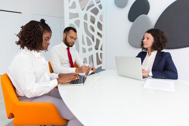 Diverse business colleagues reporting to female boss