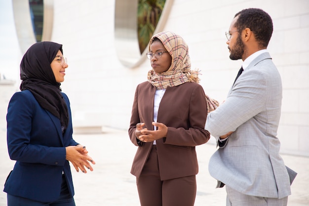 Diverse business partners meeting outside and discussing deal