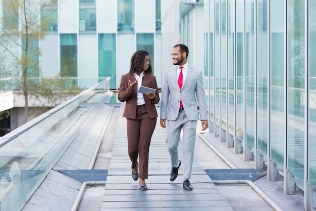 Diverse coworkers going down urban footpath