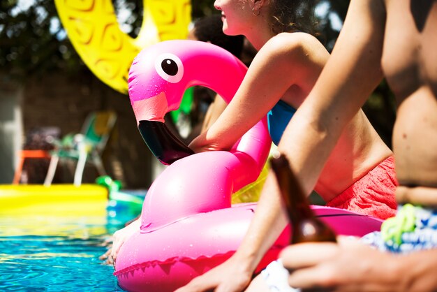 A diverse group of friends enjoying summer time by the pool with inflatable floats