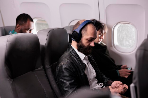 商用便で飛行機で旅行し、国際航空会社で休暇旅行に行く乗客の多様なグループ。空輸中に飛行機の座席に座っている旅行者。
