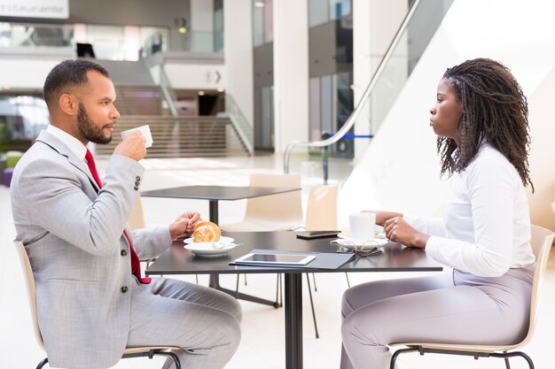 Diverse partners or colleagues meeting over cup of coffee