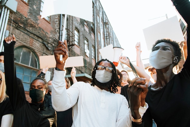Free photo diverse people wearing mask protesting during covid-19 pandemic