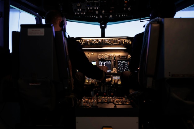 機長とパイロットの多様なチームがエンジンのスロットル レバーを押して、航空コックピットから飛行機で離陸します。ダッシュボードとコントロール パネルのコマンドを使用して飛行機のジェット機を操縦する乗組員。