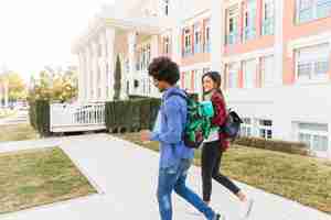 Free photo diverse teenage couple student walking together outside the university building