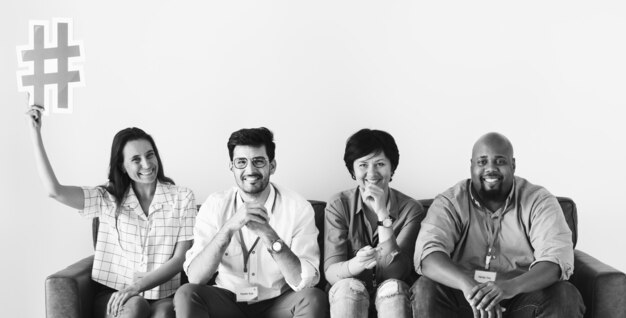 Diverse workers sitting together woman holding hashtag icon