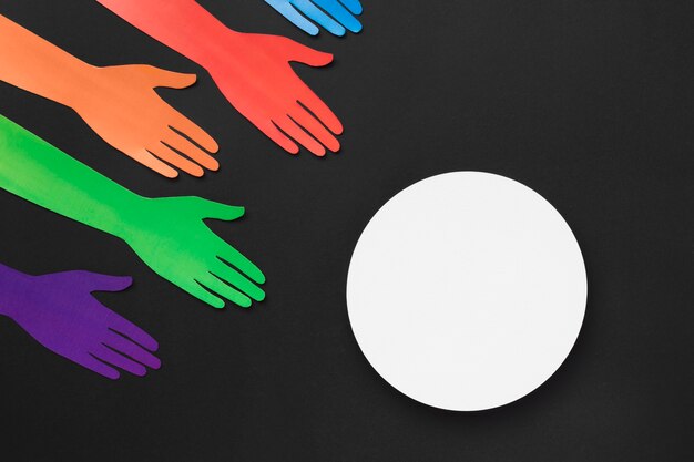 Diversity assortment of different colored paper hands with white circle