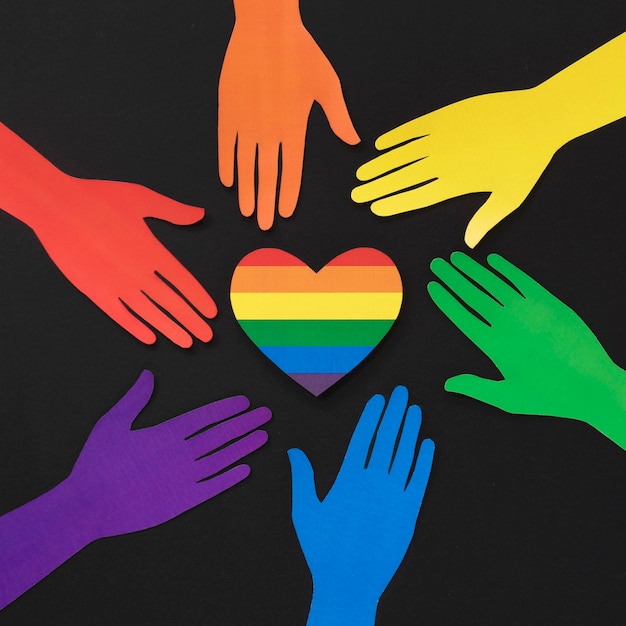 Free photo diversity composition of different colored paper hands with rainbow heart