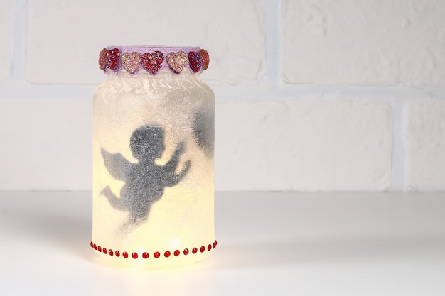 Diy fairy jar на фоне белого кирпича стены. идеи для подарка
