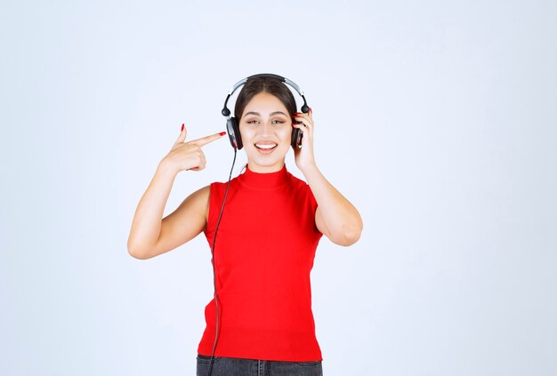 Dj girl with headphones pointing at it.