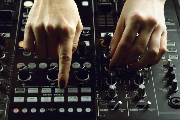 Dj playing music at mixer closeup