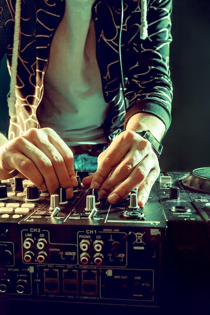 Dj playing music at mixer closeup