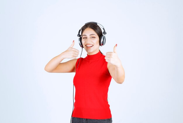 Dj in red shirt wearing headphones and enjoying the music.