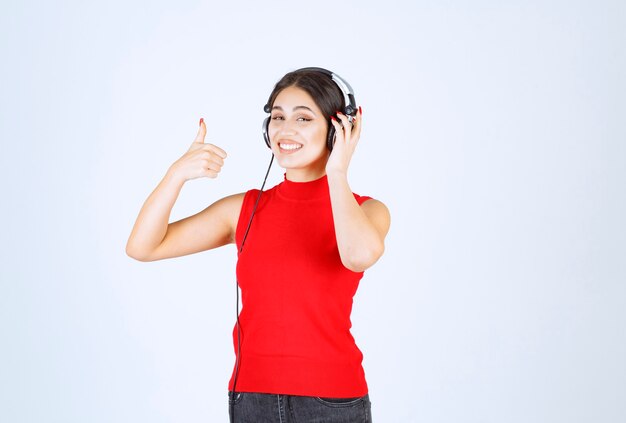 ヘッドフォンをして音楽を楽しんでいる赤いシャツの DJ。
