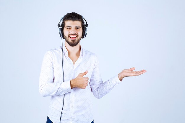 Dj with headphones dancing and pointing to somebody on the right