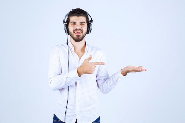 Dj with headphones dancing and pointing to somebody on the right