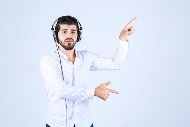 Dj with headphones dancing and pointing to somebody on the right