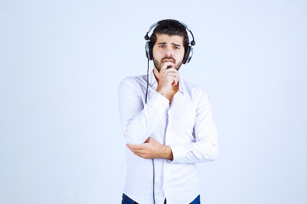 Dj with headphones looks confused and thoughtful