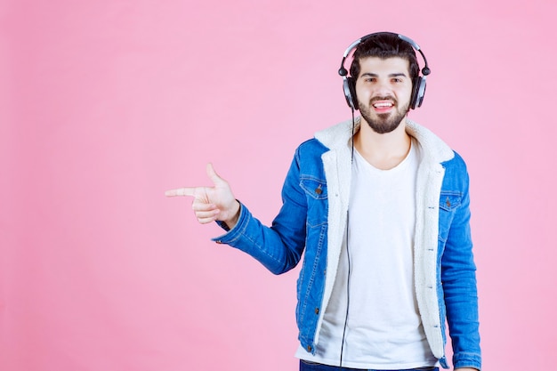 Dj with headphones pointing at somewhere