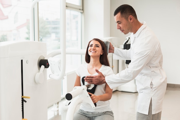 Doctor adjusting patient head in medical machine