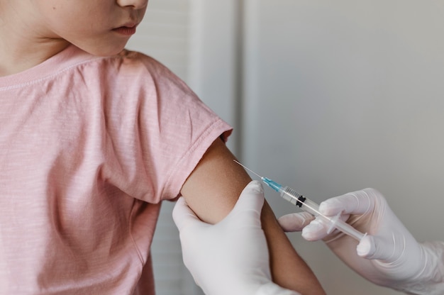 Doctor administering a vaccine to kid