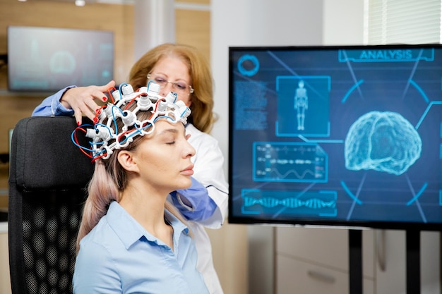 여성 환자의 머리에 스캔 장치를 배치하는 의사.