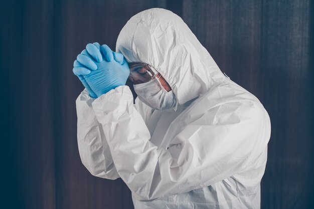 A doctor being thankful in mask, gloves and protective suit