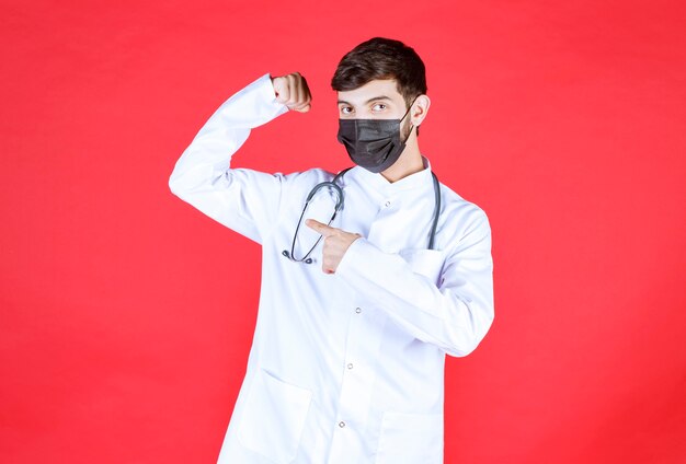 Doctor in black mask with stethoscope on the neck. 