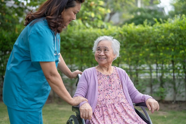 医師の介護者は、看護病院病棟で車椅子に座っているアジアの高齢者または高齢者の老婦人女性患者の健康で強力な医療コンセプトを支援し、ケアします Premium写真