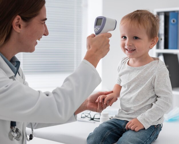 Doctor checking baby's temperature