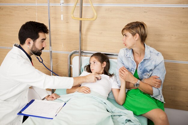 Doctor checking her patient heart in hospital room