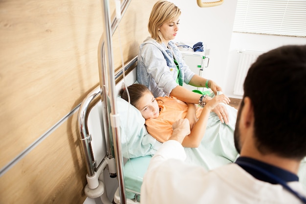 Foto gratuita dottore che controlla il cuore del suo paziente in ospedale