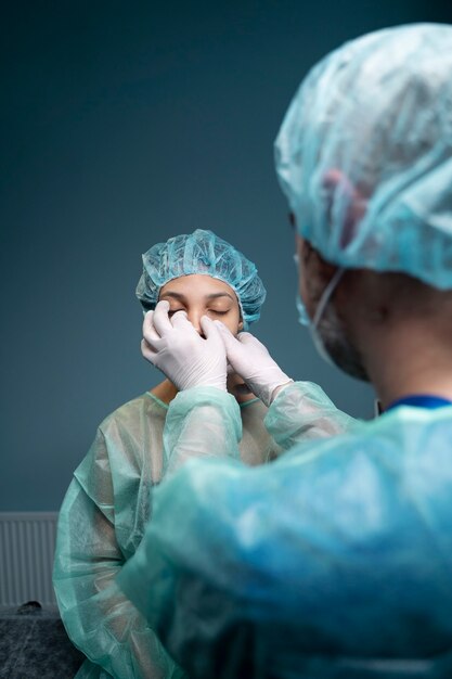 Doctor checking patient's nose at hospital