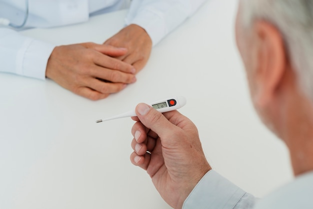 Free photo doctor checking thermometer